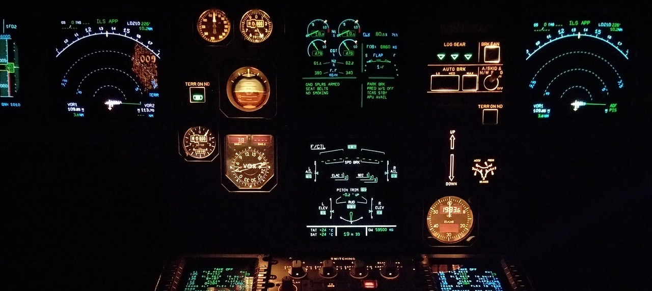 Airplane cockpit at night glowing from the lights of the dials.