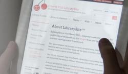 User holding an iPad and looking at the LibrarySite template.