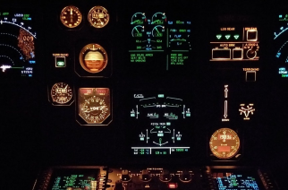 Airplane cockpit at night glowing from the lights of the dials.